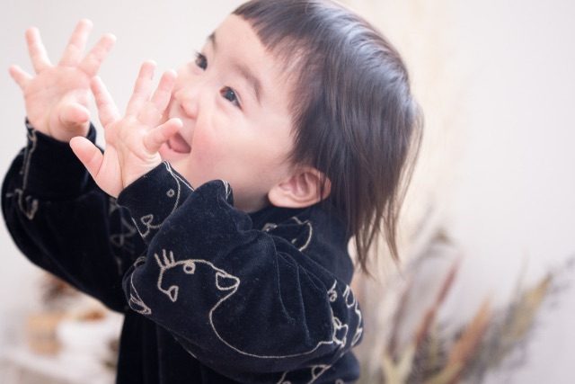 両手を広げて笑う小さな子ども